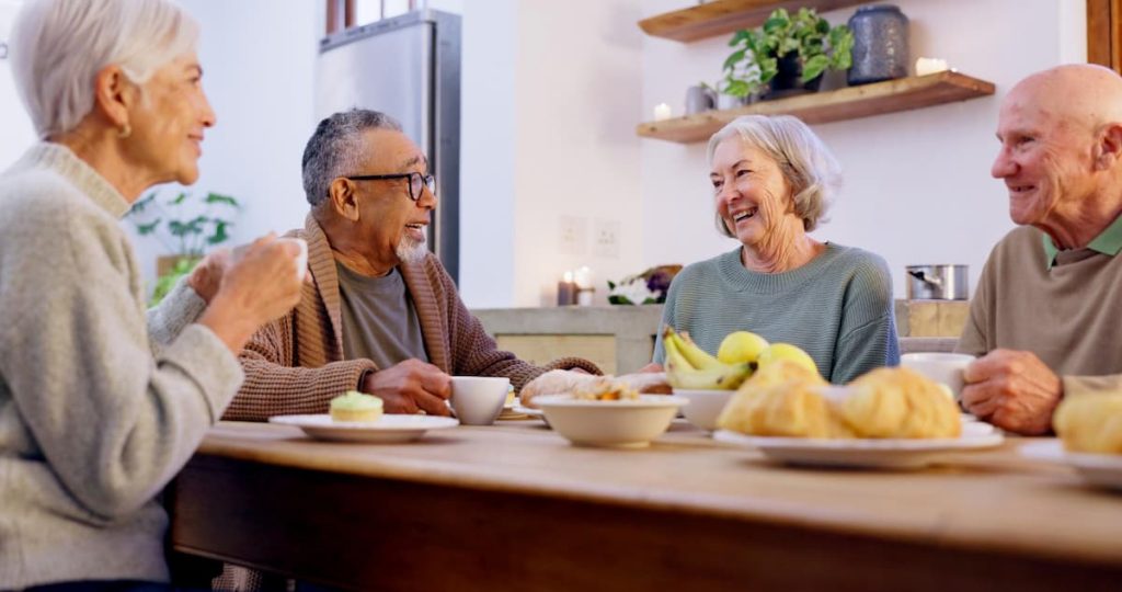 Group of seniors sharing a meal together in a supportive home sharing environment in Vancouver